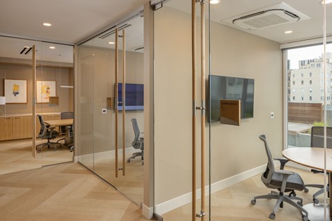 a conference room with glass walls and a table and chairs