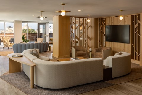 a lobby with couches and chairs and a television