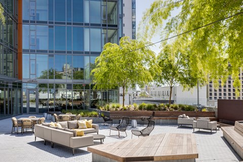 a communal area with couches and tables and chairs in front of a glass building