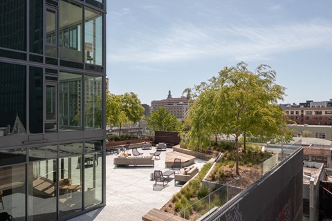 a terrace with a view of a city and a glass building