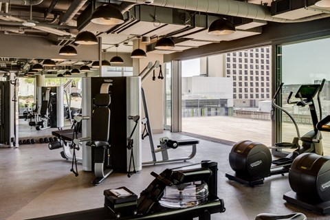 a gym with weights and other exercise equipment in a room with a large window