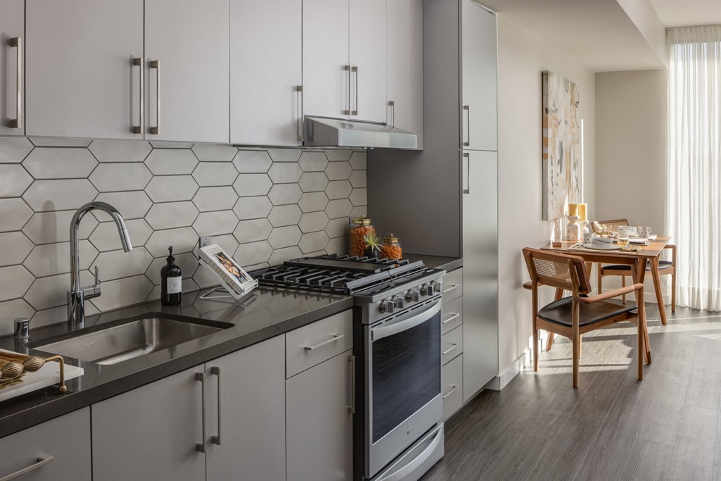 a kitchen with white cabinets and a sink and a counter top