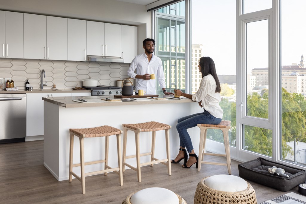 a man and a woman sitting at a counter in a kitchen