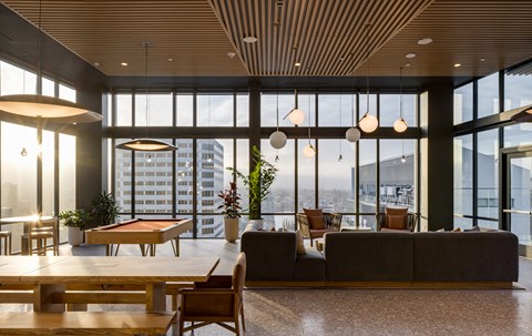 a living room with a pool table and a view of the city