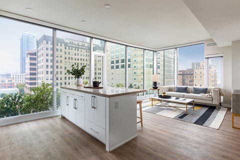 a living room with a large window and a kitchen