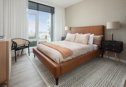 a bedroom with a bed and a large window