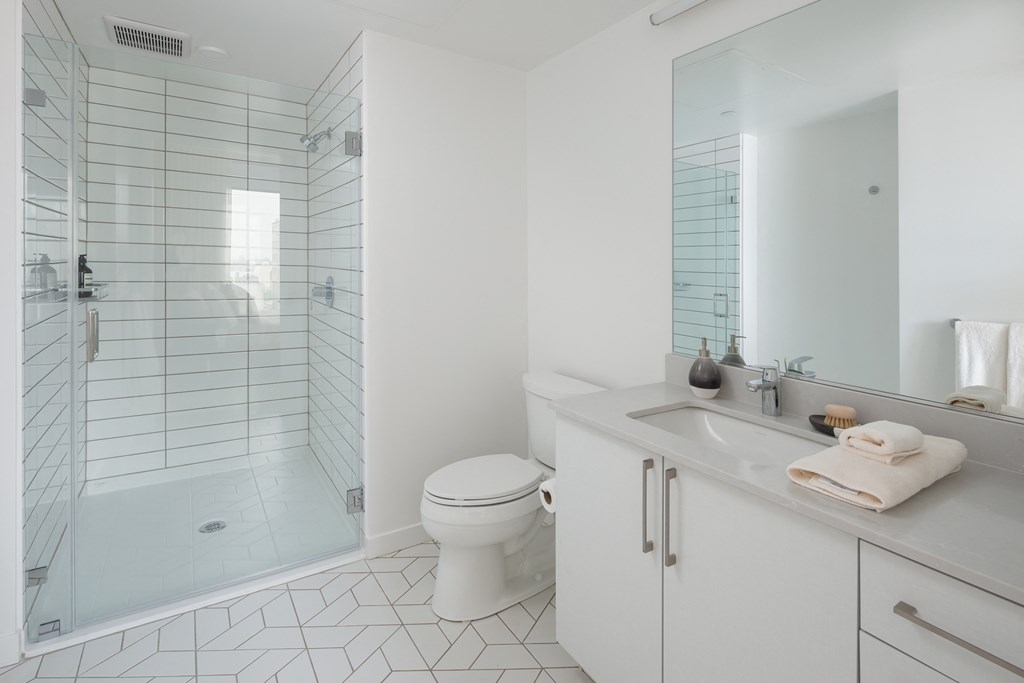 a white bathroom with a shower toilet and sink