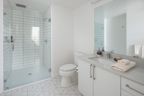 a white bathroom with a shower toilet and sink