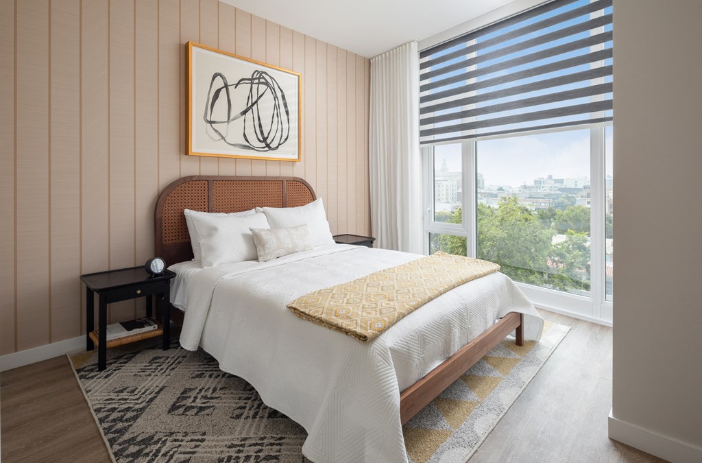 a bedroom with a bed and a large window