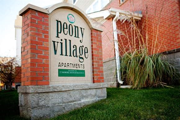 a sign apartments in front of a brick building