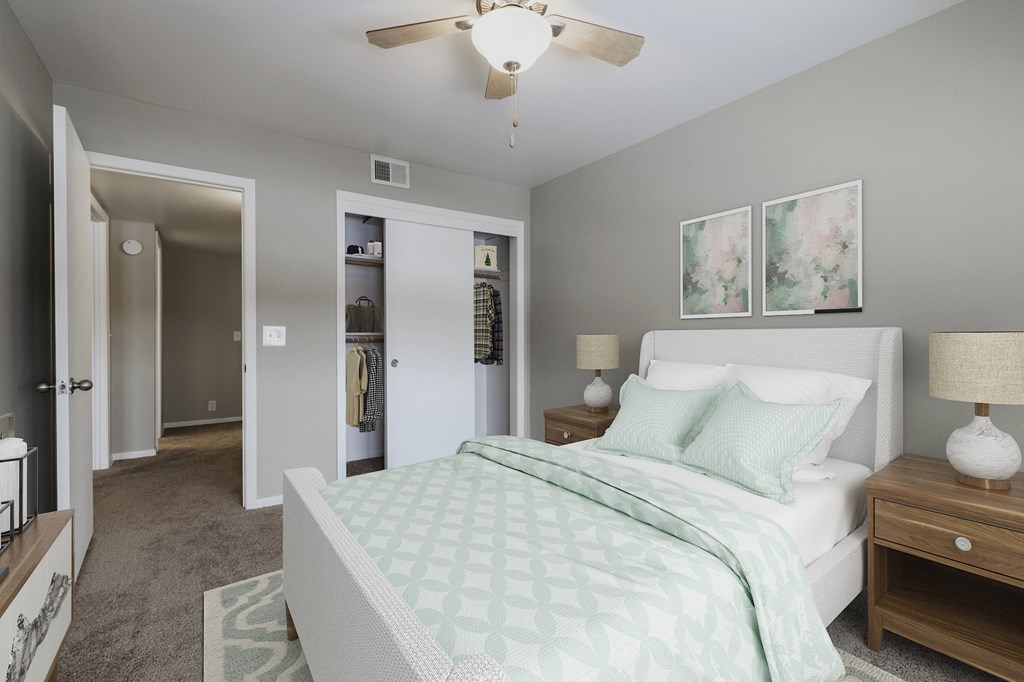 a bedroom with a white bed and a ceiling fan