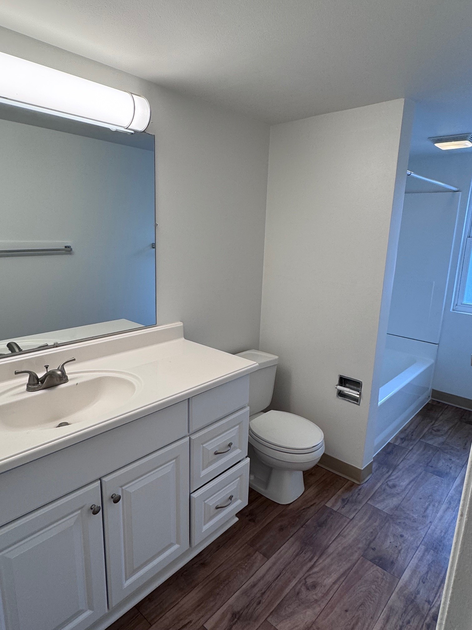 A bathroom with a sink, toilet, and mirror.