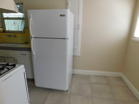 a kitchen with a refrigerator and a stove and a window
