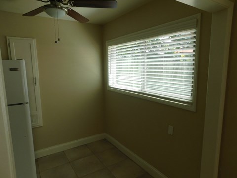 a dining room with a window and a ceiling fan