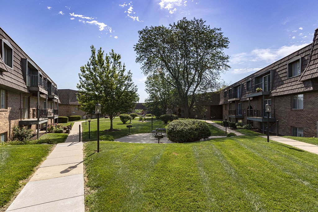 a view of a yard between two apartment buildings