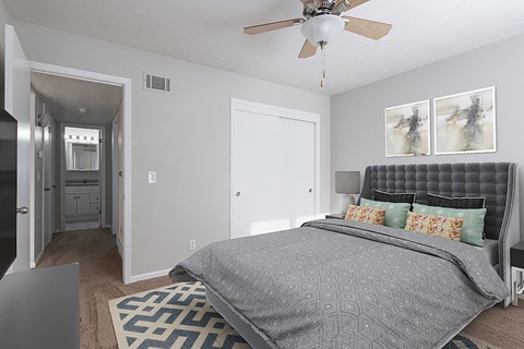 a bedroom with a bed and a ceiling fan