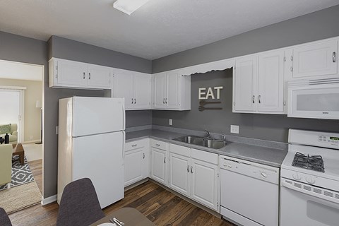 an image of a kitchen with white cabinets and a sink and refrigerator