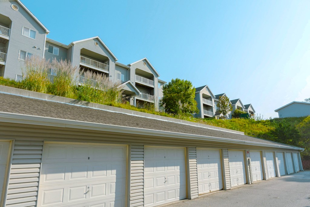 A row of garages in front of apartment buildings.