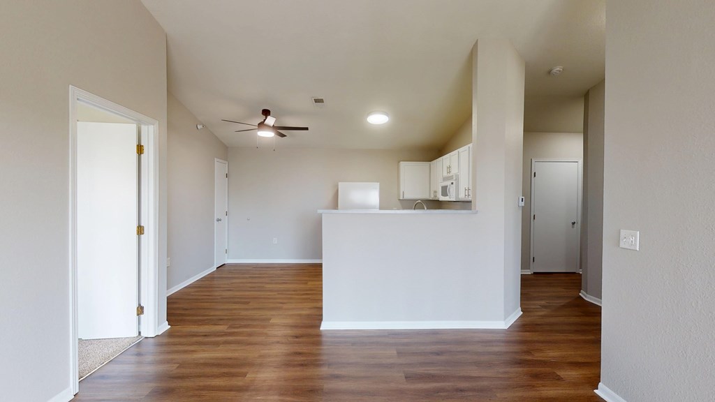 A room with a white counter and wooden floors.
