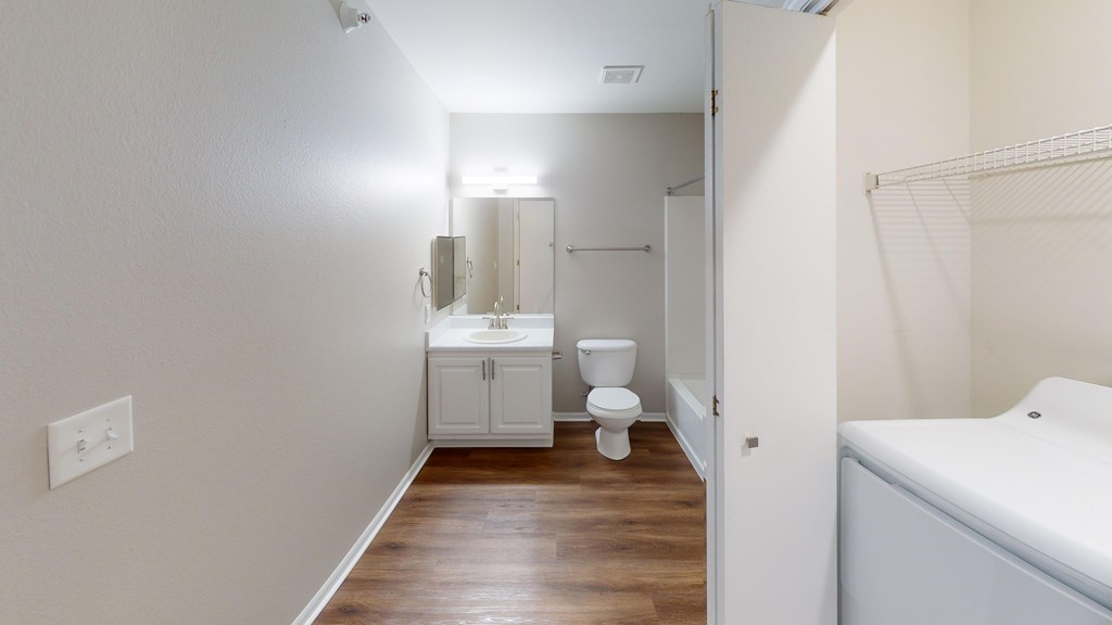 A white bathroom with a toilet, sink, and bathtub.