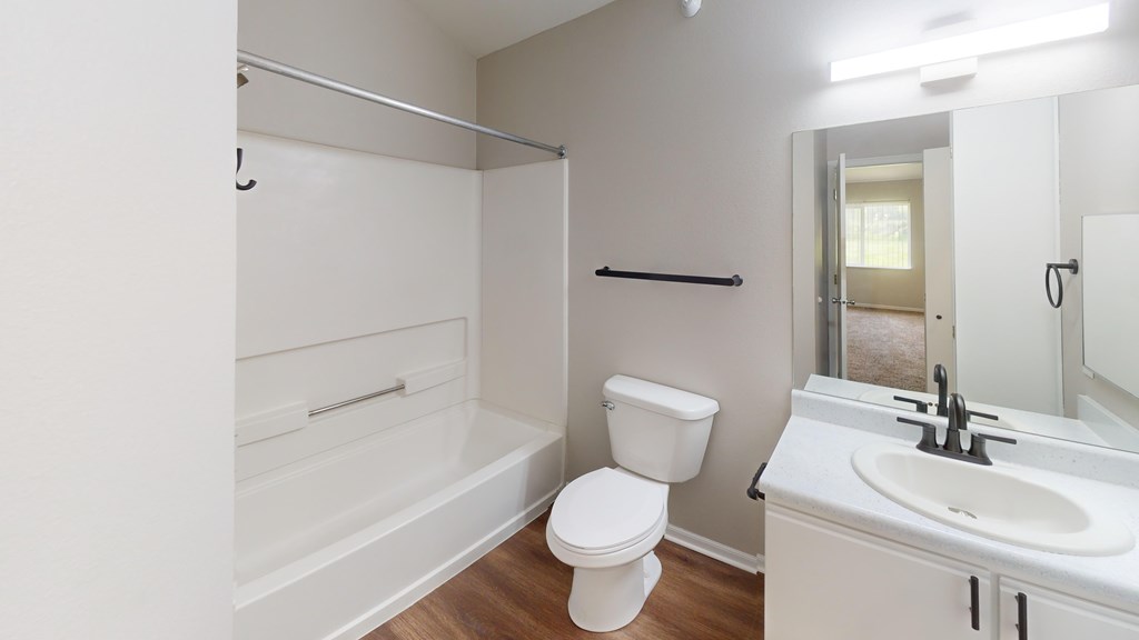 A white bathroom with a toilet, sink, and bathtub.