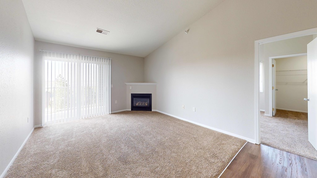 A living room with a fireplace and a carpet.