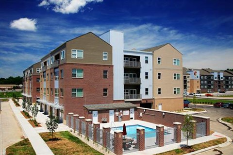 an apartment building with a pool in front of it