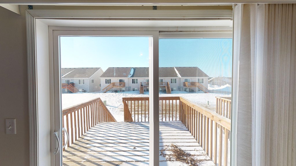 a sliding glass door leading to a deck in the snow