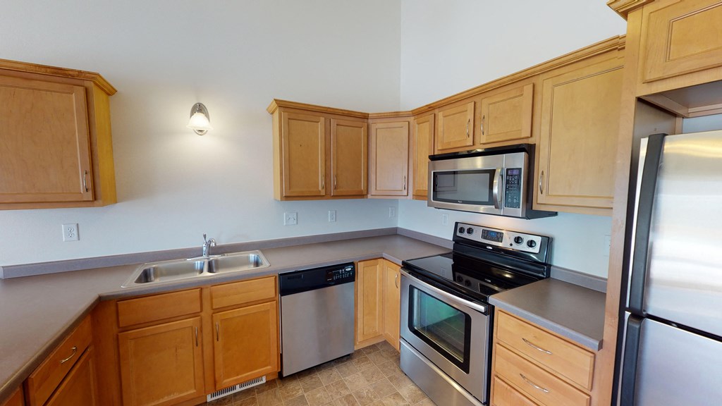 a kitchen with stainless steel appliances and wooden cabinets