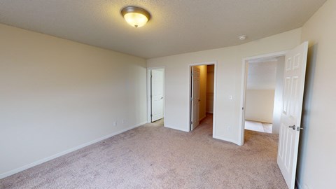 a bedroom with a carpeted floor and a door to a closet
