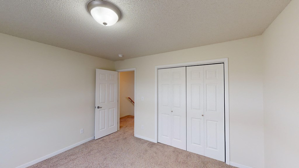a bedroom with two closets and a door to a hallway