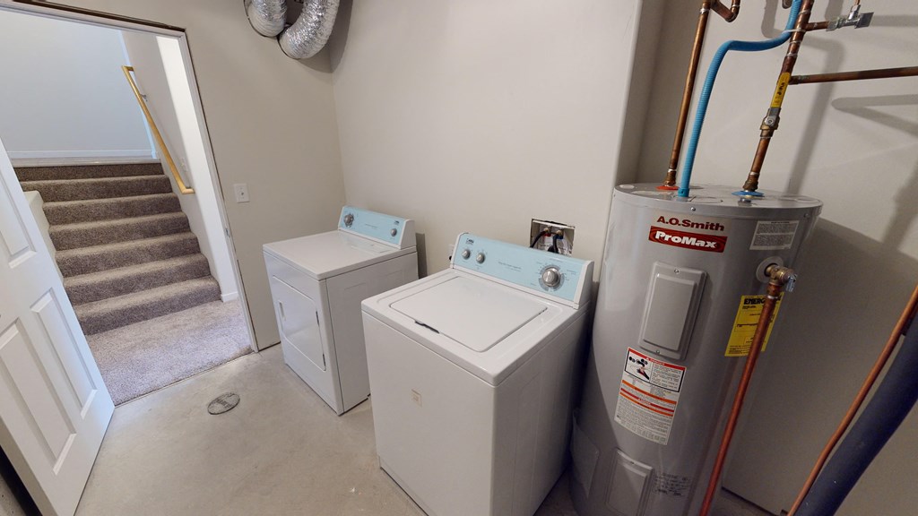 the laundry room has a washer and dryer and stairs to the attic