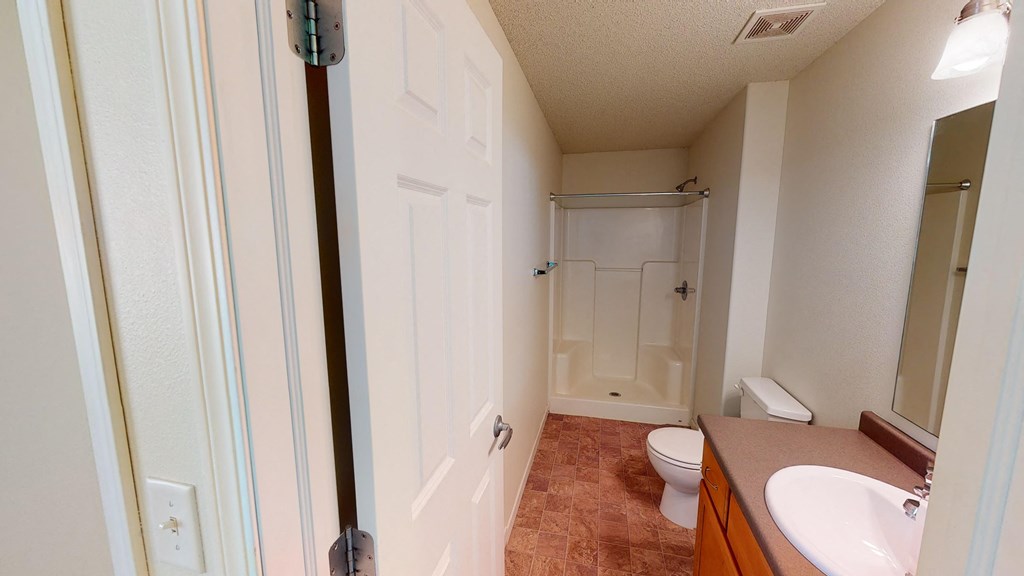 a bathroom with a toilet and a sink and a shower