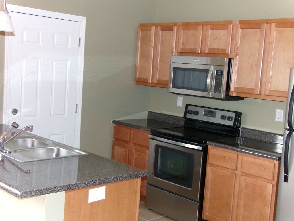a kitchen with stainless steel appliances and wooden cabinets
