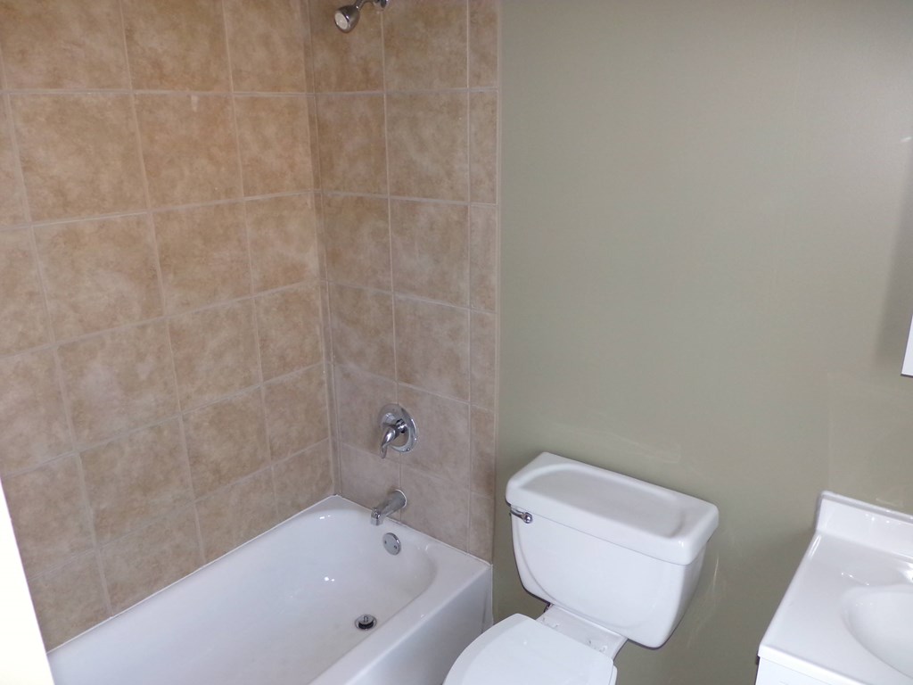 a bathroom with a toilet and a tub and a sink