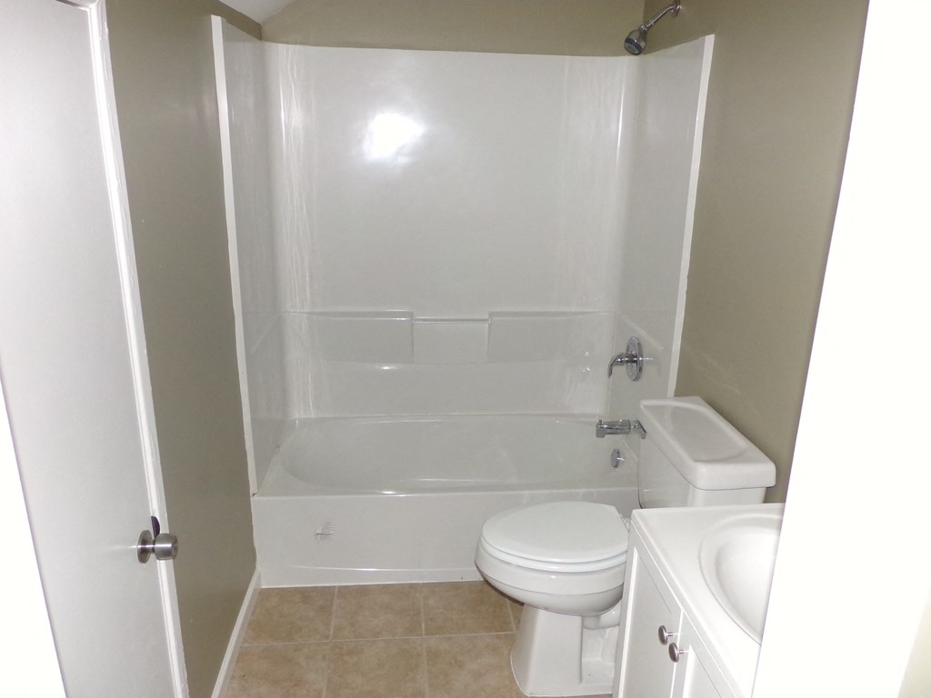 a bathroom with a toilet and a tub and a sink