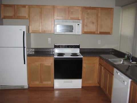 a kitchen with wooden cabinets and a stove and a microwave