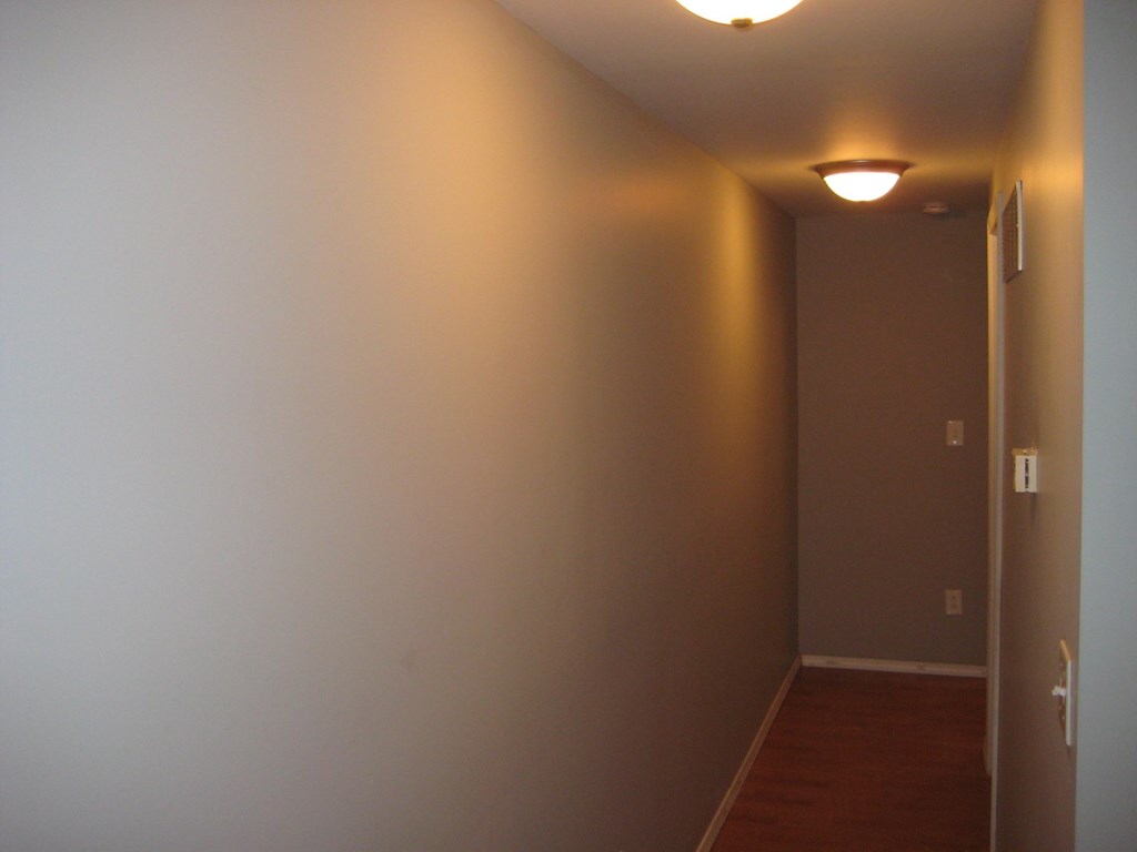 a hallway with a light on the ceiling and a door to a room
