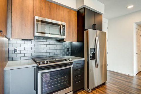 A modern kitchen with a stainless steel refrigerator and oven.