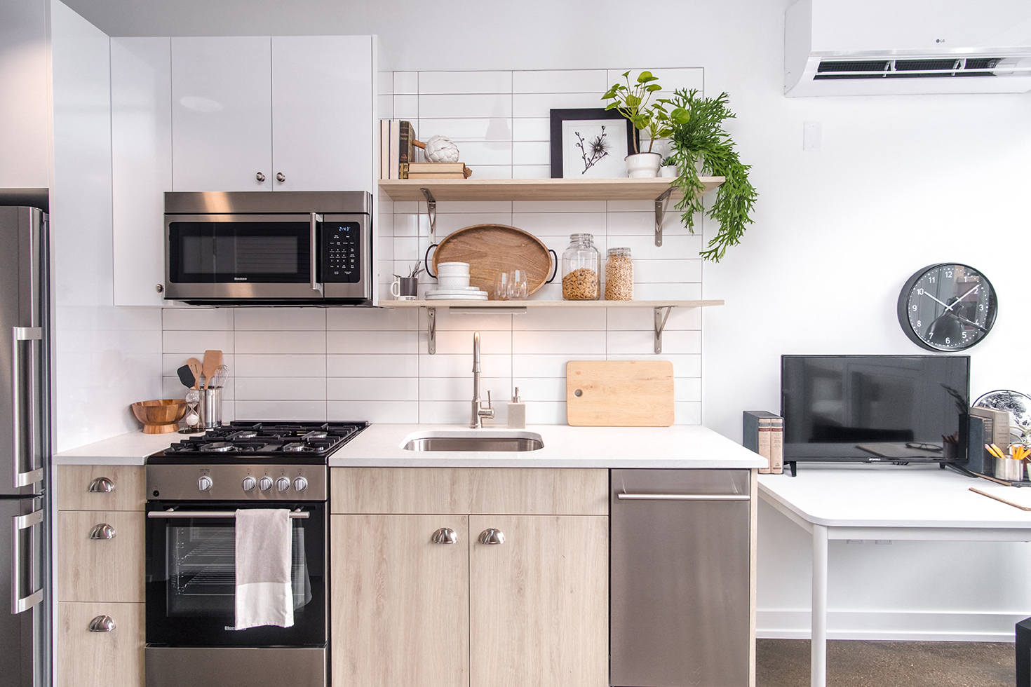 a white kitchen with wooden cabinets and stainless steel appliances