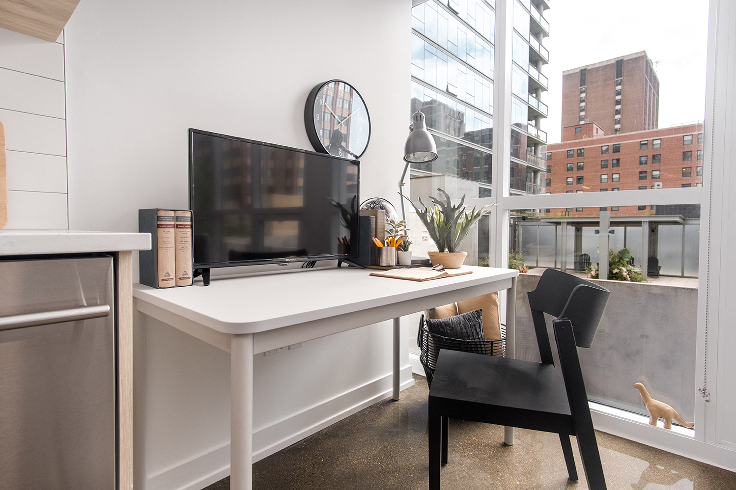 a home office with a desk and a large window