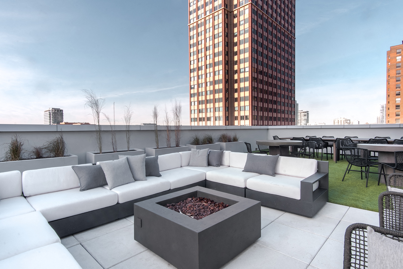 a lounge area on the roof of a building with a fire pit