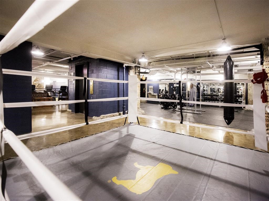 a boxing ring in a gym with a yellow logo on the floor