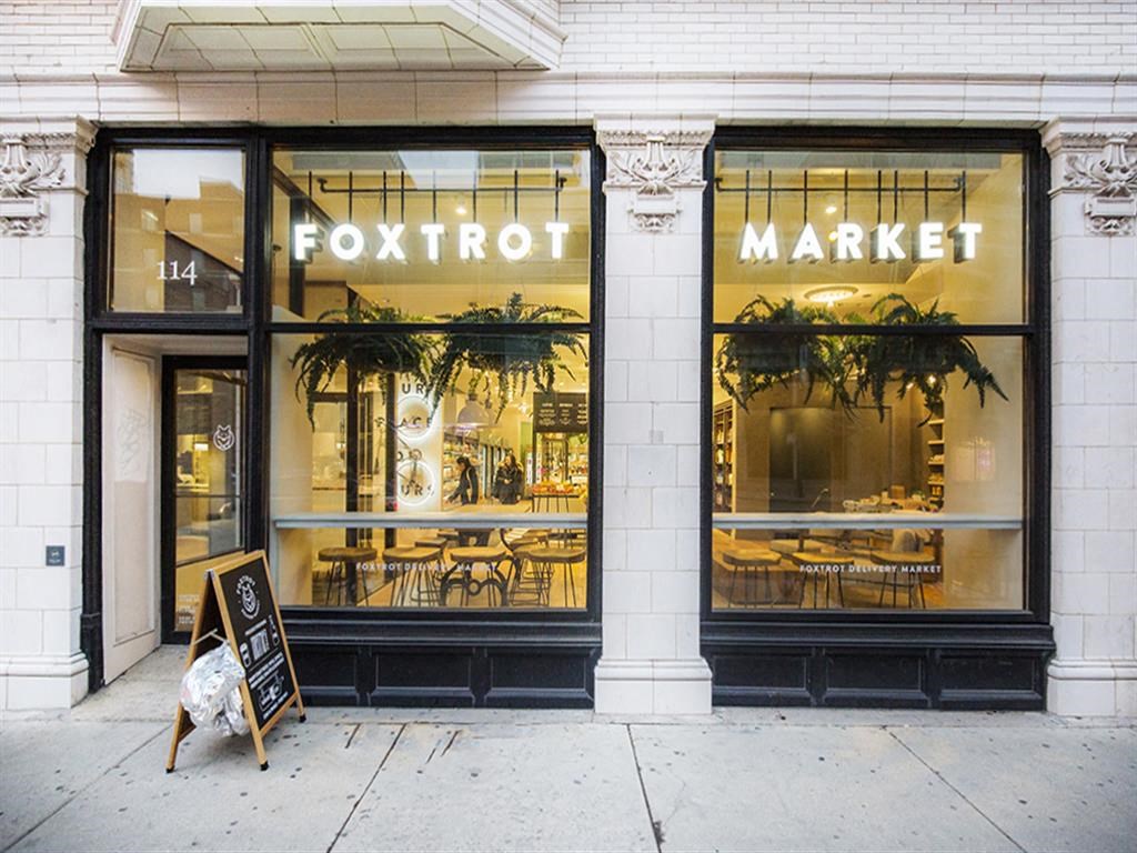 a store front of a store with a sign on the sidewalk