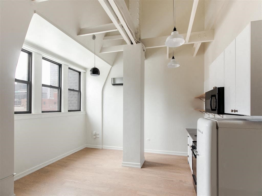 an empty kitchen with a microwave and a refrigerator