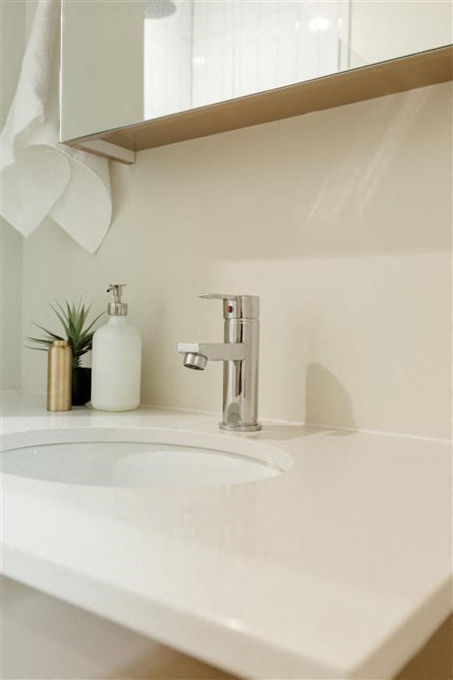 a bathroom sink with a soap dispenser and a mirror