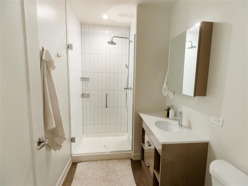 a bathroom with a shower and a sink and a mirror