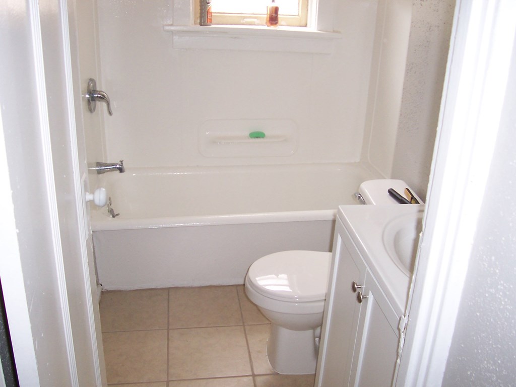 a bathroom with a toilet and a tub and a sink