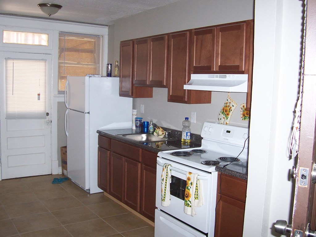a kitchen with white appliances and wooden cabinets