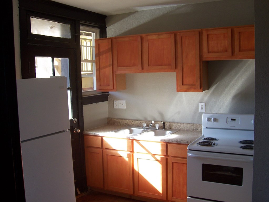 a kitchen with white appliances and wooden cabinets